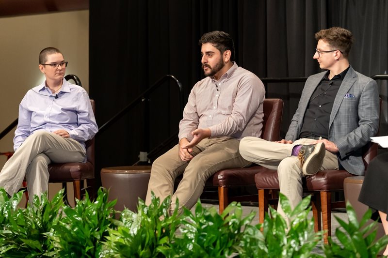 Photo of Delaney Couri, Fabian Leon and Bryton Praslicka on stage with Dr. Jennifer Strong for the 2023 Dinner & Dialogue panel discussion